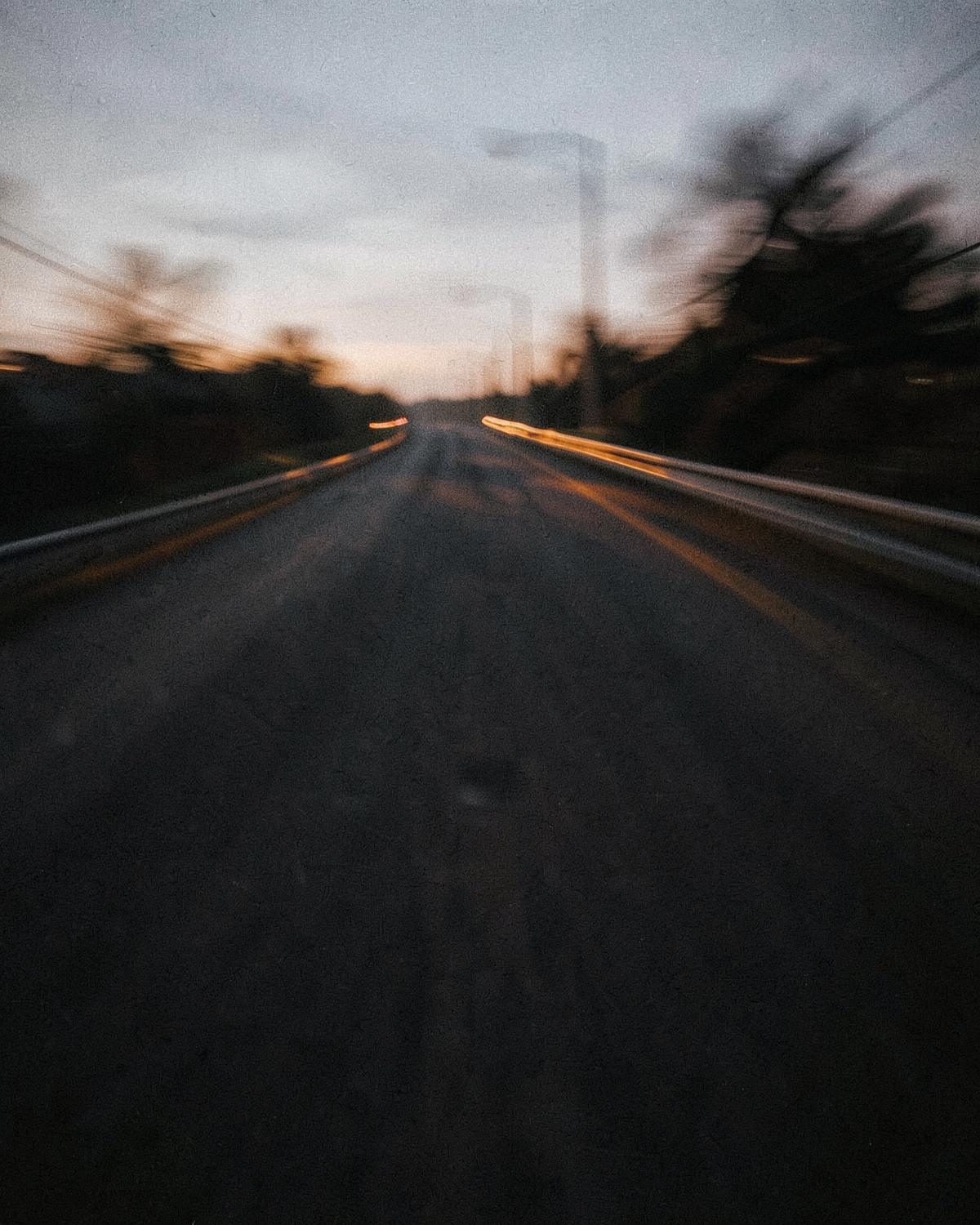 Open road at dusk with warm light trails